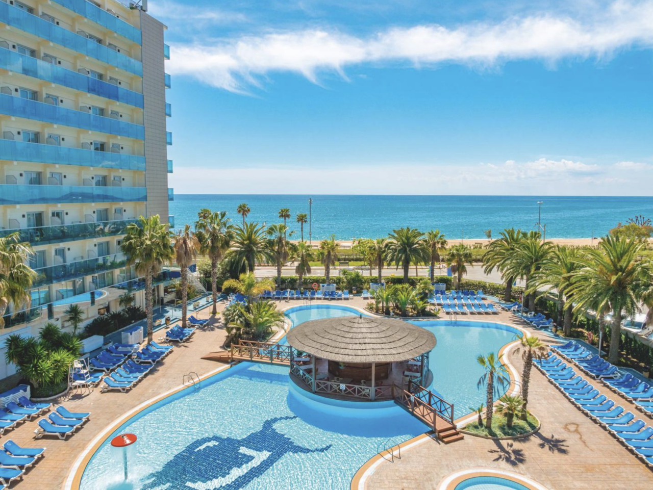 Buitenaanzicht van het 4*-Hotel Golden Taurus Aquapark Resort met zwembad en strand in zicht.